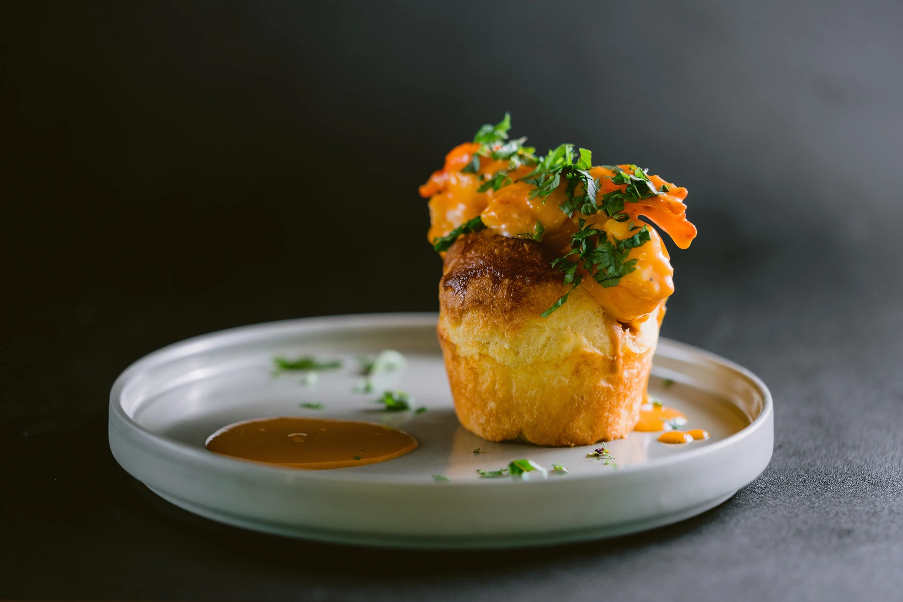 A savoury pastry topped with prawns and herbs, plated at Seed in Bingin
