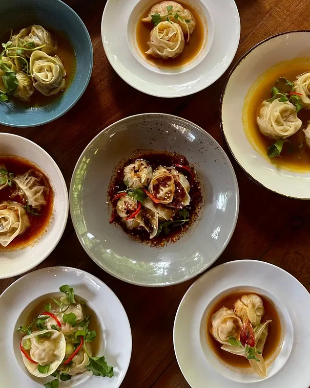 Eight bowls of dumplings in different broths, photographed from above at Seed