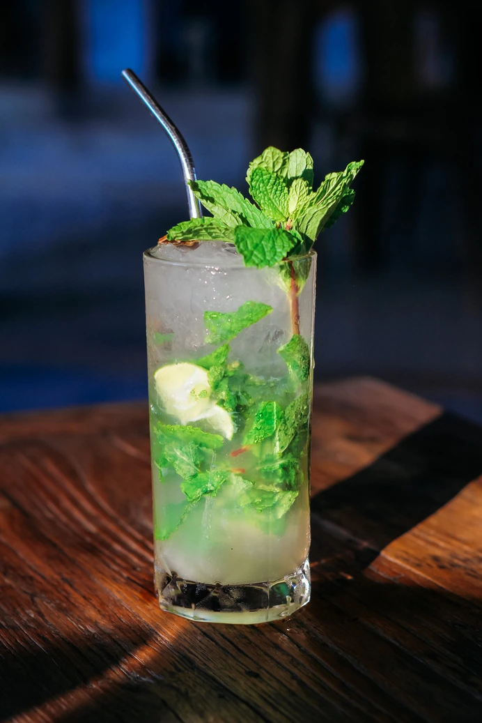 A mojito with fresh mint on a wooden table at Seed in Bingin